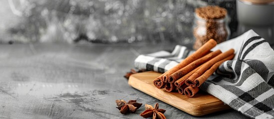 Poster - Cinnamon sticks on the board with a plaid towel in the home interior. with copy space image. Place for adding text or design