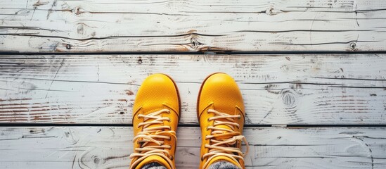 two pairs of yellow winter boots on an old white wooden floor with a copy space on the center pastel background