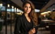 © imagineRbc - A woman in a business suit holding a tablet. She is smiling and looking at the camera. Concept of professionalism and confidence