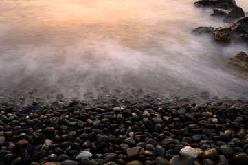 Wall Mural - Very beautiful mediterranean seascape with setting sun on sunset. Waves crash on rocks in nature.