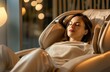 © Ruslan Gilmanshin - Young woman relaxing on the massaging chair at home