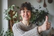 © CogniLens - Portrait of a happy woman in her 40s showing a thumb up over scandinavian-style interior background