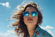© Jati - A woman with long hair and sunglasses is wearing a blue floral dress