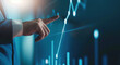 © Leonardo - Uomo d'affari che tocca con la mano un grafico a linee ascendenti su uno schermo virtuale, concetto di crescita del business