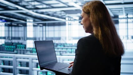 Poster - system administrator in data center typing on laptop, running error checking utilities to fix proble