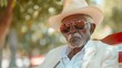 © Iuliia Metkalova - Elegant Senior African American Man in Stylish White Suit and Hat in Summer Park. Generative ai