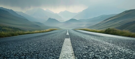 Wall Mural - Asphalt road in the mountains with soft sky on the background. Copy space image. Place for adding text or design