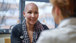 © Daniel - Portrait of bald woman talking to a doctor comforting and congratulating her during consultation on alopecia and cancer recovery