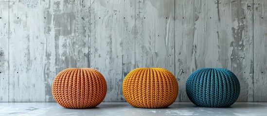 Poster - Three colorful knitted poufs in front of a concrete wall. Copy space image. Place for adding text and design