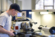 © industrieblick - young apprentice in vocational training working on a turning machine in the industry