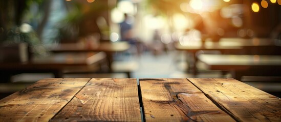 Wall Mural - Selected focus empty brown wooden table and Coffee shop or restuarant blur background with bokeh image. for your photomontage or product display. Copy space image