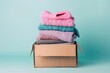 © melody_a_m - Box of clothes on pastel background, donation and reuse concept