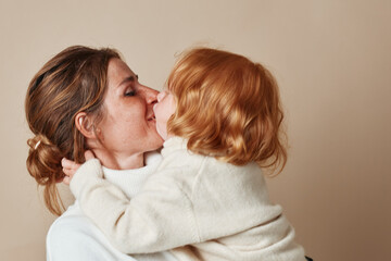 Wall Mural - Tender moment mother kissing daughter in arms, love and family, bonding embrace, parenting connection, affectionate parentchild relationship