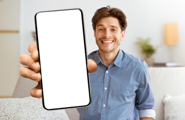 Poster - A smiling man holds a smartphone with a blank white screen, looking directly at the camera.