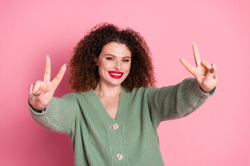 Wall Mural - Photo of cheerful good mood woman wear stylish khaki clothes demonstrate v-sign isolated on pink color background