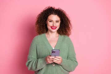 Wall Mural - Photo of cheerful cute woman wear trendy khaki clothes hold apple iphone isolated on pink color background