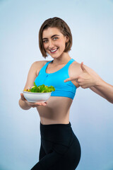 Wall Mural - Full body length gaiety shot athletic and sporty young woman with healthy vegan food in standing posture on isolated background. Healthy active and body care by vegetarian lifestyle.
