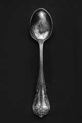 Aufkleber - A single spoon on a black surface with a black background
