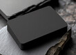 © Montree - Minimalistic stack of black business cards on slate rock background, perfect for branding identity mockups.