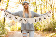 © Sean Locke - Autumn: Woman Holds Up Happy Fall Banner