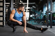 © Prostock-studio - Sporty man at gym doing stretching exercises for legs, empty space