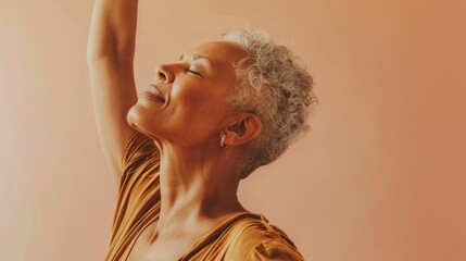 Wall Mural - Woman with gray hair closed eyes and raised arm exuding a sense of joy or relief against a warm soft-focus background.