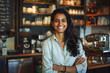 © Pacharee - Happy Indian woman standing in coffee shop.