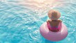 © shooreeq - Woman in hat floats on an inflatable donut mattress in pool, view from back, sunny day, summer vacation, happy relaxing time