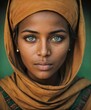 © MeSSrro - A beautiful african girl with dark brown skin wearing a brown hijab scarf and looking at camera with her blue eyes.