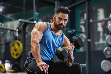 Canvas Print - A man with a beard lifts weights in a gym, demonstrating strength and focus.