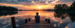 © VISUAL BACKGROUND - A man sitting on a dock looking at the sunset.