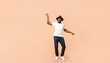 © Prostock-studio - Stylish young African American guy wearing hat dancing, having fun over beige studio background, panorama with copy space