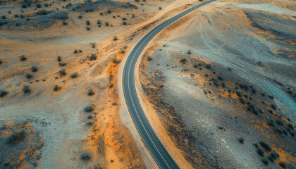 Wall Mural - Aerial view of an empty road passing through a remote desert landscape