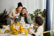 © LIGHTFIELD STUDIOS - An African American man and woman sit with a child at a table, showing love and togetherness.