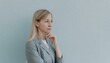 © anastasiia - A thoughtful, depressed, baffled woman on a greyish background