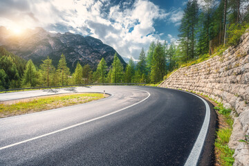 Wall Mural - road in mountains at sunset in summer. dolomites, italy. beautiful roadway, green tress, high rocks,