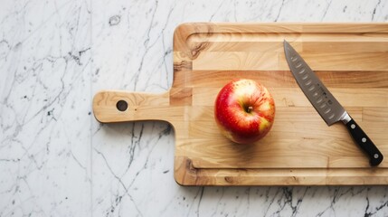 Wall Mural - A minimalistic kitchen scene with a wooden cutting board, a knife, and a single apple on a marble countertop