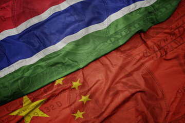 Wall Mural - waving colorful flag of gambia and national flag of china on the dollar money background. finance concept.