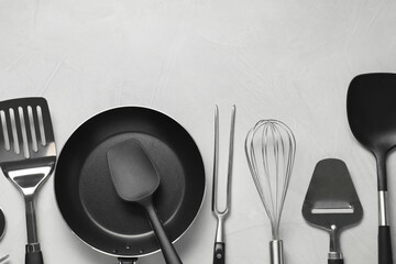 Wall Mural - Different spatulas and other kitchen utensils on grey background, flat lay