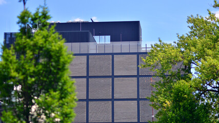 Wall Mural - Exterior of a modern industrial building with green environment. Corporate building reduce CO2. Eco building.