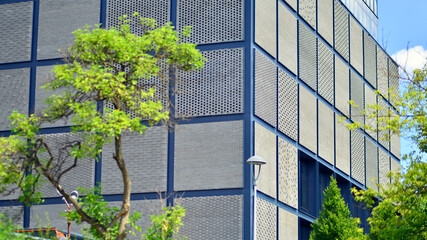 Wall Mural - Exterior of a modern industrial building with green environment. Corporate building reduce CO2. Eco building.