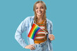 © Pixel-Shot - Beautiful young woman with LGBT flag on blue background