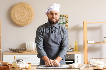 Canvas Print - Male baker preparing dough at table in kitchen