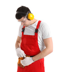 Wall Mural - Young carpenter in hearing protectors with bag of tools on white background