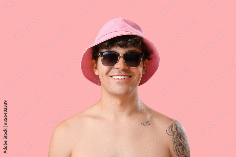 Young man in sunglasses and bucket hat on pink background, closeup