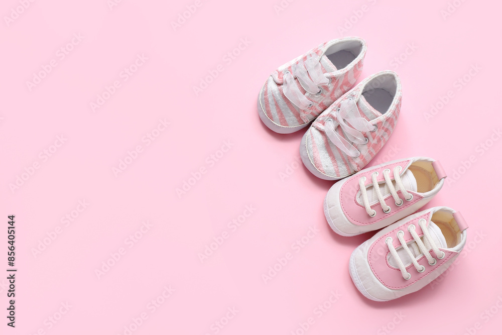 Stylish baby booties on pink background