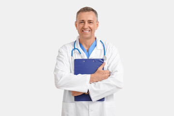 Wall Mural - Mature doctor with clipboard on white background