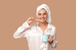 © Pixel-Shot - Young woman with toothbrush and cup on brown background