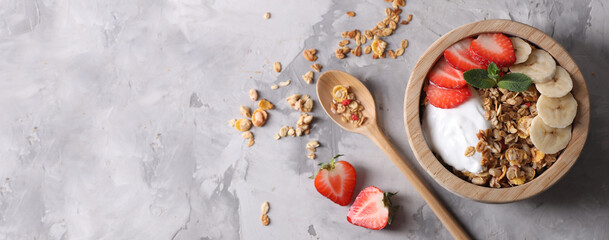 Canvas Print - Tasty granola with yogurt, strawberry and banana on grey table, top view. Banner design with space for text