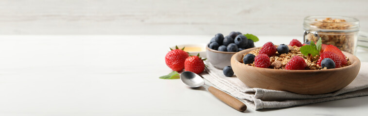 Poster - Tasty granola with berries on white table. Banner design with space for text
